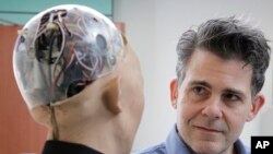 FILE - In this Sept. 28, 2017, photo, David Hanson, the founder of Hanson Robotics, talks with his company's flagship robot Sophia, a lifelike robot powered by artificial intelligence in Hong Kong. 