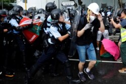Police try to disperse protesters near a flag raising ceremony for the anniversary of Hong Kong handover to China in Hong Kong, July 1, 2019.