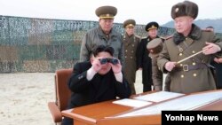 Shimoliy Koreya rahbari Kim Chen Un durbindan raketa uchirish mashqini tomosha qilmoqda, Pxenyan, 2014-yil, 30-dekabr.