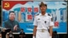 在香港海軍基地，一位中國水兵站在一面具有中共黨旗、習近平像和香港景象的大型看板前面（2017年7月8日）。