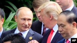 Le président russe Vladimir Poutine et le président américain Donald Trump discutent à Danang, Vietnam,11 novembre 2017. 