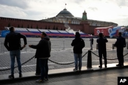 People look at the empty Red Square closed for Victory Parade preparation next to the Moscow Kremlin, in Moscow, Russia, Wednesday, May 3, 2023. Russian authorities have accused Ukraine of attempting to attack the Kremlin with two drones overnight. The Kremlin on Wednesday decried the alleged attack attempt as a "terrorist act" and said Russian military and security forces disabled the drones before they could strike.