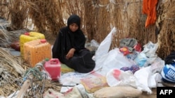 FILE - A Yemeni woman sits in the remains of a home in a neighborhood ravaged by Tropical Cyclone Sagar, in the port city of Hodeidah, Yemen, May 19, 2018
