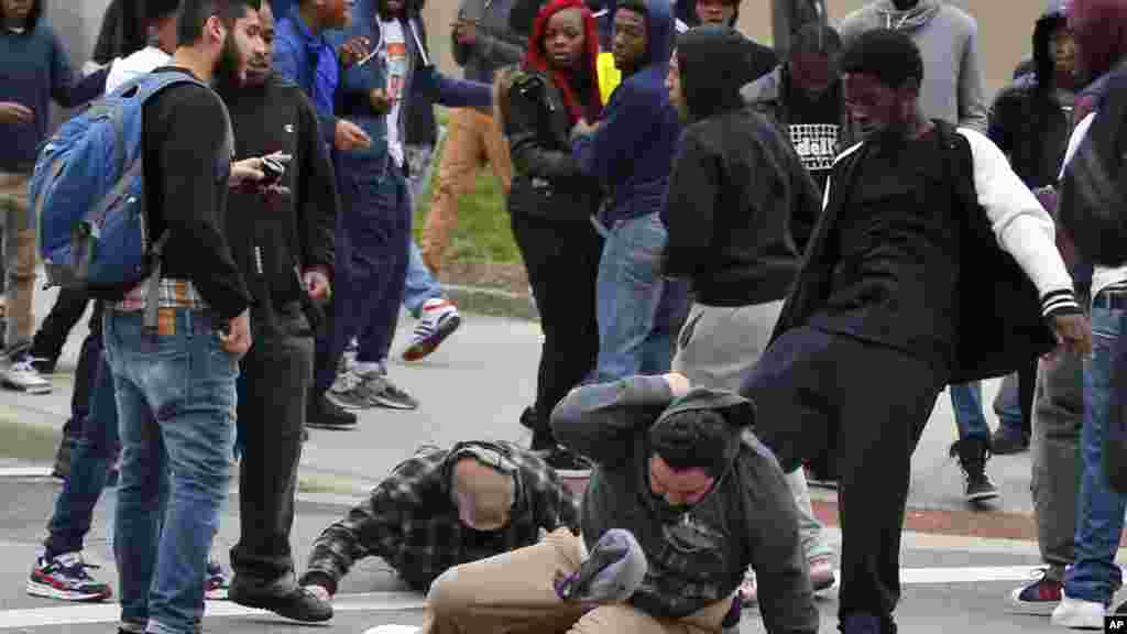 Seorang pria ditendang saat mencoba bangkit setelah dipukul jatuh dalam demonstrasi untuk Freddie Gray di Baltimore (25/4). (AP/Alex Brandon)