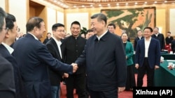 2025年2月17日，中國國家主席習近平在北京出席民營企業座談會時與民營企業家代表握手。