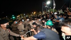 Pengunjuk rasa pro-demokrasi menarik barikade baja di depan polisi ketika mereka mencoba bergerak maju selama unjuk rasa di Bangkok, Thailand, 13 Februari 2020. (Foto: AP)