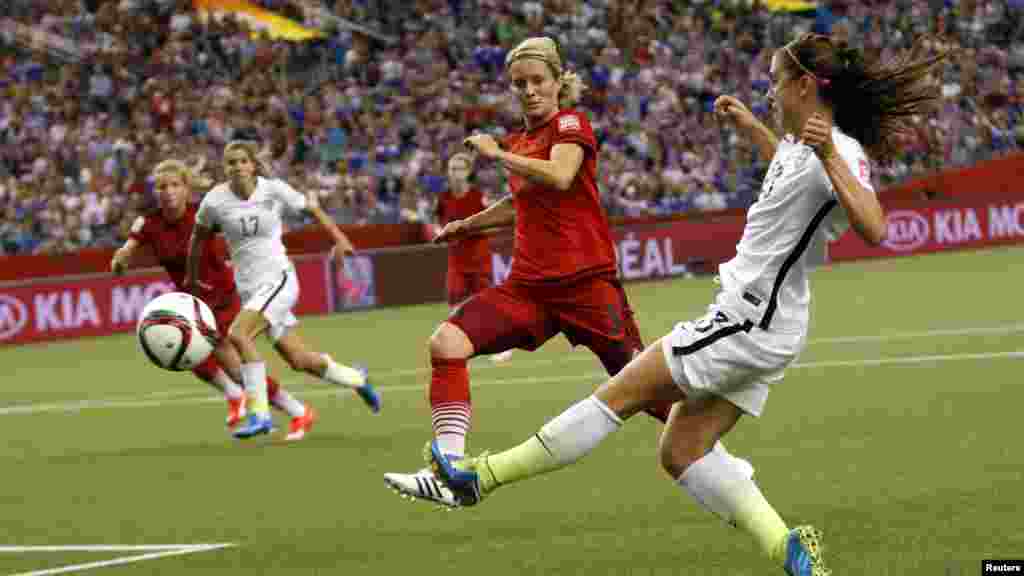 'Yar wasan Amurka Alex Morgan (13) da abokiyar wasa Saskia Bartusiak (3) a gasar kofin duniya na kwallon kafar mata (FIFA) a kasar Kanada. 30 ga watan Yuni, 2015