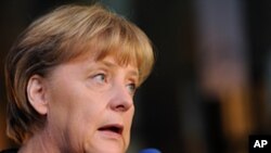 German Chancellor Angela Merkel talks with journalists as she arrives for a meeting ahead of an EU summit in Brussels, October 22, 2011.
