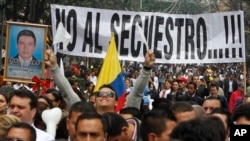 ARCHIVO - Personas marchan con un cartel que dice en español: "No al secuestro" durante una marcha contra el secuestro en Bogotá, Colombia, el martes 6 de diciembre de 2011.
