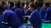 FILE - A prisoner carries her daughter during a ceremony at Prey Sar prison in Phnom Penh, March 8, 2015. Twenty-two female prisoners who are either pregnant or have kids were released by the Cambodian government for International Women's Day. 
