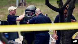 Pasukan penjinak bom kepolisian Nashville memakai peralatan sebelum memeriksa sebuah alat di samping gedung bioskop menyusul penembakan Rabu (5/8) di Antioch, Tennessee. (AP/Mark Zaleski)