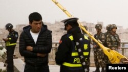 资料照：警察在新疆喀什街头检查一名男子的身份证。(2017年3月24日)