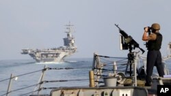 ARCHIVO - El portaaviones USS Dwight D. Eisenhower y otro buque de guerra cruzan el Estrecho de Ormuz hacia el Golfo Pérsico el domingo 26 de noviembre de 2023, como parte del despliegue en Medio Oriente por la guerra entre Israel y Hamás. 