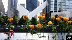 Flowers are seen placed into the groves of inscribed names of the victims of the 9/11 terrorist attacks, at the National September 11 Memorial and Museum, Sept. 11, 2020, in New York City.