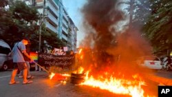 Para pengunjuk rasa membakar ban selama demonstrasi flash mob yang menyerukan boikot terhadap sistem pendidikan di bawah pemerintahan militer, 10 November 2021. (Foto: AP)