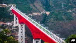 Voz železnice Kina-Laos prelazi veliki most na reci Juangđiang u provinciji Junan. Kina-Laos je jedan od stotina projekata u okviru programa Pojas i put.