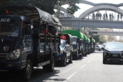 Polisi duduk di dalam truk-truk yang terparkir di sebuah jalan di pusat Kota Yangon, Myanmar, Senin, 1 Februari 2021.