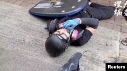 一名香港反送中抗議者被警察發射的子彈打中倒在地上。（2019年10月1日） 