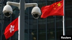 資料照：在香港總部大樓外監控攝像頭後的中國國旗和香港特區旗幟。