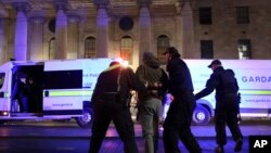 La policía irlandesa realiza un arresto cerca de la Oficina General de Correos en Dublín, el 24 de noviembre de 2023, mientras la policía mantenía una gran presencia tras una noche de protestas y violencia el jueves.