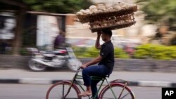 Un Égyptien équilibre un panier de pain, au Caire, le 8 décembre 2016. (AP Photo / Amr Nabil, File)