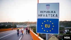 Migran menyeberangi jembatan di atas sungai Danube ke Kroasia. (Foto: dok). Polisi perbatasan di pelabuhan Giurgiu sungai Danube di perbatasan Rumania-Bulgaria mengatakan mereka menemukan 22 pria, sembialn perempuan dan 17 anak-anak termasuk seorang bayi, Kamis malam (29/12). 
