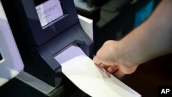 FILE - In this June 13, 2019, photo, Steve Marcinkus, an Investigator with the Office of the City Commissioners, demonstrates the ExpressVote XL voting machine at the Reading Terminal Market in Philadelphia. 