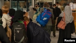 Ciudadanos estadounidenses y sus familias son procesados en la Base Aérea de Ramstein para abordar un vuelo en su camino a los Estados Unidos, en Alemania, el 23 de agosto del 2021.
