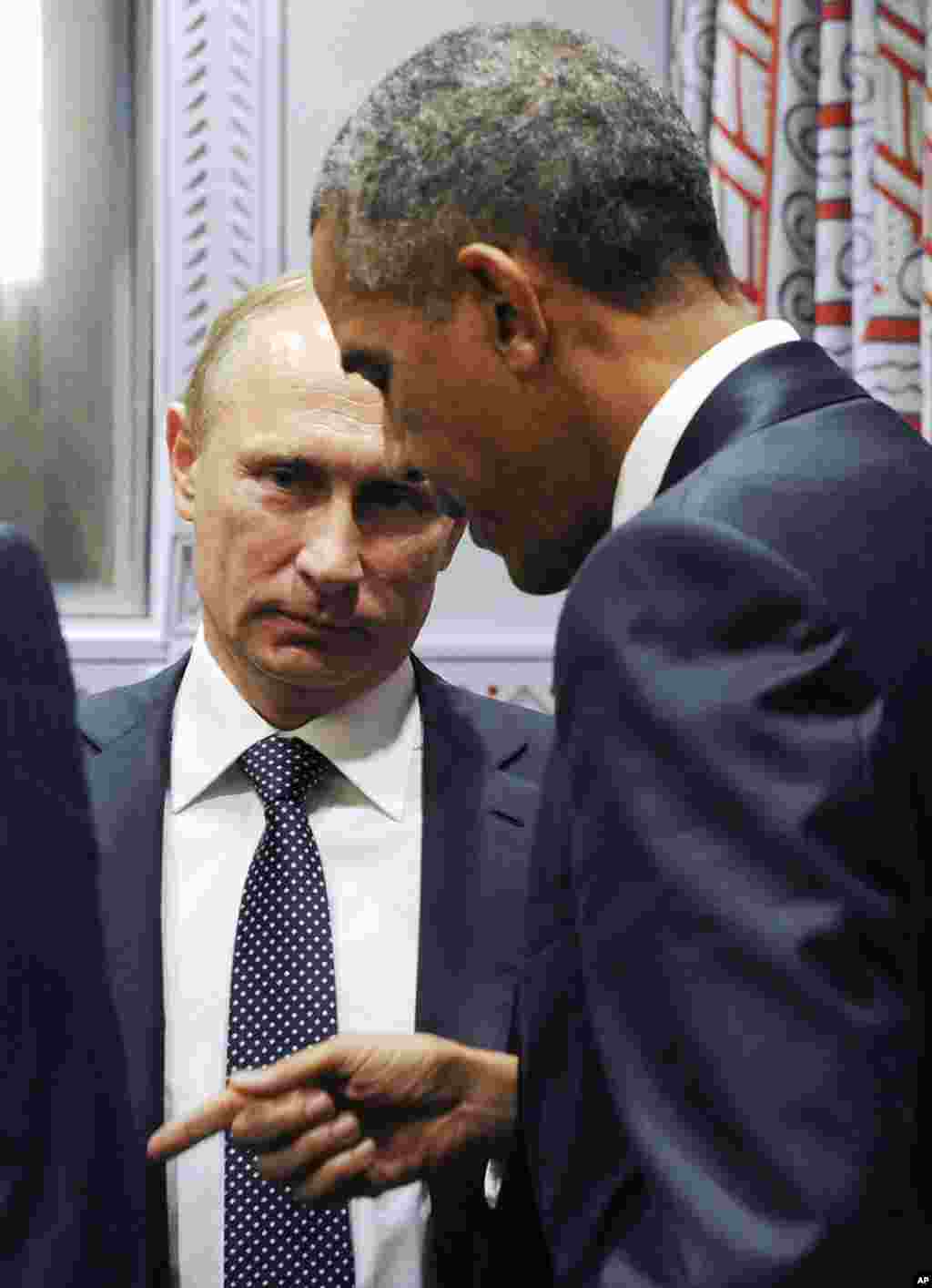 U.S. President Barack Obama gestures while speaking to Russian President Vladimir Putin before a bilateral meeting at United Nations headquarters in New York, Sept. 28, 2015. 