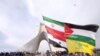 FILE - A man carries a giant banner comprising the flags of Iran, Syria, the Palestinian territories and Hezbollah, during a ceremony marking the 37th anniversary of the Islamic Revolution, in Tehran, Febr. 11, 2016. (REUTERS/Raheb Homavandi/TIMA)