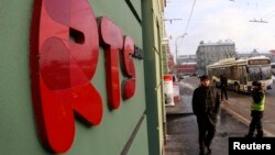 FILE- A man passes by the office of the Moscow Exchange, Russia's main venue for trading in stocks, bonds, foreign exchange and derivatives.