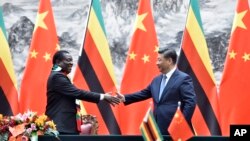 Zimbabwean President Emmerson Mnangagwa, left, shakes hands with Chinese President Xi Jinping as they pose for the media after a signing ceremony at the Great Hall of the People in Beijing, China, April 3, 2018.