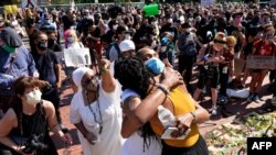Unas manifestantes se abrazan durante la protesta del 19 de junio en honor de Rayshard Brooks y otras víctimas de la violencia policial en Boston, Massachusetts, el 22 de junio de 2020. 