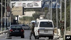 Syrian soldiers at a checkpoint northeast of Damascus, Aug. 29, 2011.
