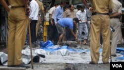 Pihak berwenang di India memeriksa puing-puing ledakan di Opera House, Mumbai, salah satu lokasi serangan dari tiga ledakan bom hari Rabu (13/7).