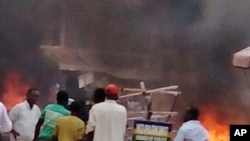 Mutane na kallon wajenda Bom ya fashe a birnin Jos, dake Jihar Filato. 