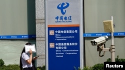 一名女子走过北京的中国电信办公楼。（2020年8月11日）