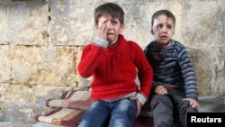 FILE - Injured boys react at a field hospital after airstrikes on the rebel-held areas of Aleppo, Syria, Nov. 18, 2016. 