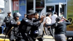 Agentes antidisturbios desalojan a periodistas de la entrada del edificio sede de la Jefatura de la Policía Nacional, en Managua, Nicaragua. Foto: Reuters/Oswaldo Rivas.