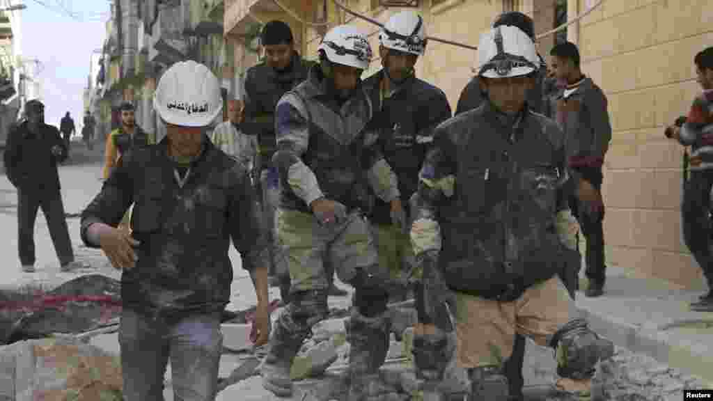 Rescuers walk on the rubble of collapsed buildings after what activists said was an airstrike by forces loyal to Syrian President Bashar al-Assad in Aleppo, Feb. 14, 2014.