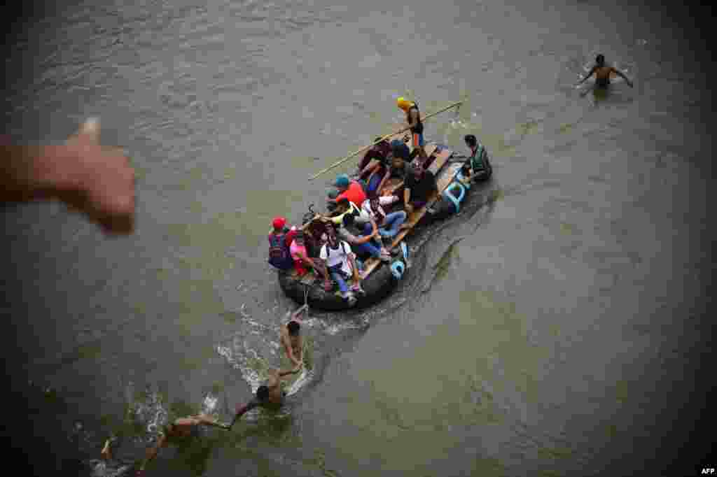 Migrantes hondureños en una balsa improvisada en el río Suchiate desde el puente internacional en la frontera entre Guatemala y México en Ciudad Hidalgo, estado de Chiapas, México, el 20 de octubre del 2018.