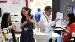 Vendors explain their products on the opening day of the Computex exhibition at the Taipei World Trade Center in Taipei, Taiwan, June 5, 2012.