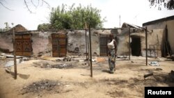 Une femme devant des maisons incendiées après une explosion provoquée par des combattants de Boko Haram dans l'Etat d'Adamawa , le 10 mai 2015, au Nigeria.