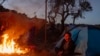 ARCHIVO - Migrantes intentan mantenerse calientes cerca de la frontera de Jacumba, en California, el 6 de junio de 2021.