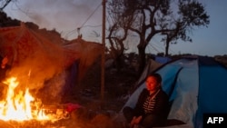 ARCHIVO - Migrantes intentan mantenerse calientes cerca de la frontera de Jacumba, en California, el 6 de junio de 2021.