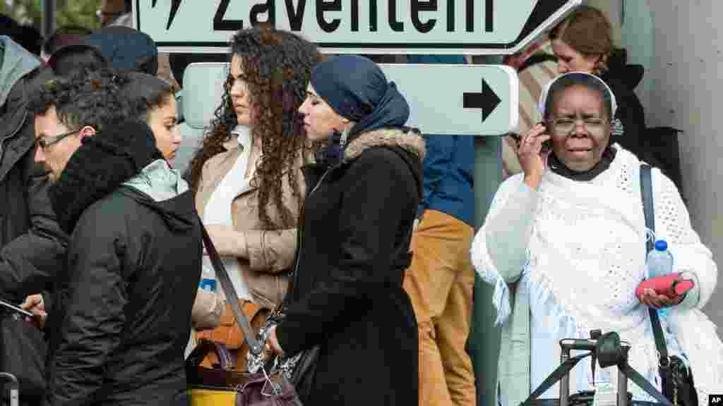 Des passagers devant l'aéroport de Bruxelles, le 22 mars 2016.
