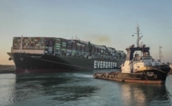 In this photo released by Suez Canal Authority, the Ever Given, a Panama-flagged cargo ship, is pulled by one of the Suez Canal tugboats, in the Suez Canal, Egypt, Monday, March 29, 2021. Engineers on Monday "partially refloated " the colossal…