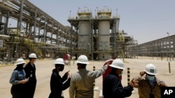 Insinyur dan jurnalis Saudi Aramco melihat proyek gas Hawiyah di Hawiyah, di Provinsi Timur Arab Saudi pada 28 Juni 2021. (Foto: AP)