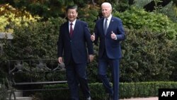 El presidente estadounidense Joe Biden (izq) y el presidente chino Xi Jinping caminan juntos después de una reunión durante la semana de líderes del Foro de Cooperación Económica Asia-Pacífico (APEC) en Woodside, California, el 15 de noviembre de 2023.