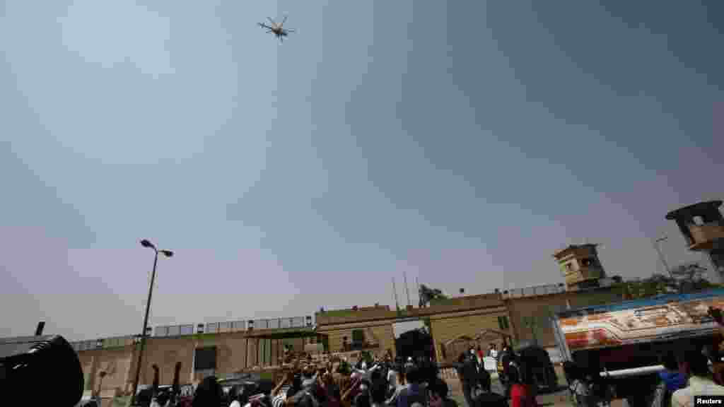 Supporters of deposed Egyptian president Hosni Mubarak gesture as the helicopter carrying him leaves Tora prison, Cairo, August 22, 2013.